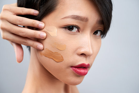 Woman Applying Foundation Swatches On Cheek