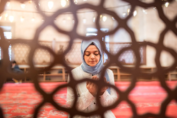 Obraz na płótnie Canvas Muslim woman in headscarf and an hijab prays