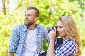 Man and woman having date outdoor. Girl wit a photo camera and her boyfriend.