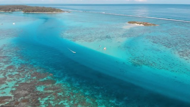 Aerial Descend: Vibrant Blue Ocean With Vacationers On Sunny Day in Moorea, French Polynesia