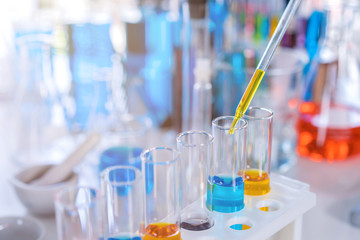 scientist with equipment and science experiments, laboratory glassware containing chemical liquid for research or analyzing a sample into test tube in laboratory
