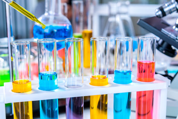 scientist with equipment and science experiments, laboratory glassware containing chemical liquid for research or analyzing a sample into test tube in laboratory