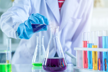 scientist with equipment and science experiments, laboratory glassware containing chemical liquid...