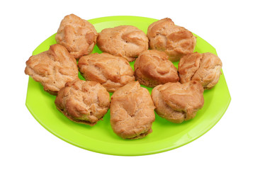 Homemade soft sweet eclairs pastries on a green plate isolated