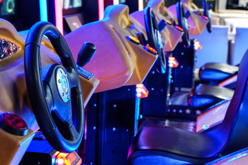Car driving machines at arcade games in the entertainment zone in shopping center - obrazy, fototapety, plakaty