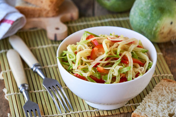 Salad with green radish and bell pepper in a white bowl 