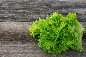 Fresh lettuce leaves on rustic wooden background 