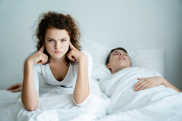 Caucasian Couple on bed with white mattress Man snoring loud makes women feel annoyed. Causes...