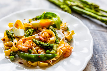 Pasta with shrimps and green asparagus with peas.