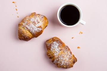 White cup of coffee and two croissants on the pink pastel color background. Flat lay, top view