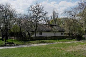  Old ukrainian house.Ukrainian hut of the nineteenth century. Spring landscape, blooming trees.Pirogovo village.
