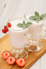 Delicious strawberry yogurt with mint leaves in glasses.