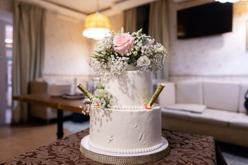 Wedding cake decorated with flowers on the table in a restaurant