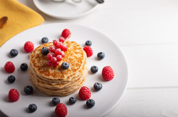 pancakes with raspberries and blueberries on a white background