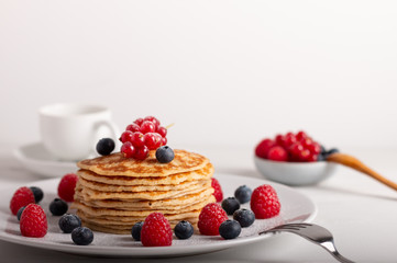 pancakes with raspberries and blueberries on a white background