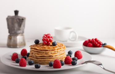pancakes with raspberries and blueberries on a white background