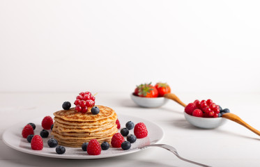 pancakes with raspberries and blueberries on a white background