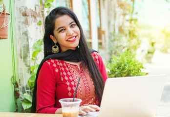 Indian woman with laptop in a cafe