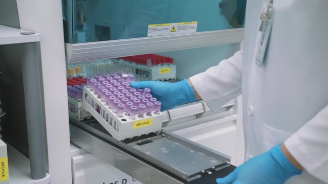 Putting Test Tube Racks Inside A Medical Laboratory Equipment