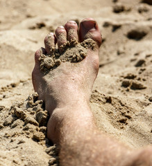 Feet of a man in the sand