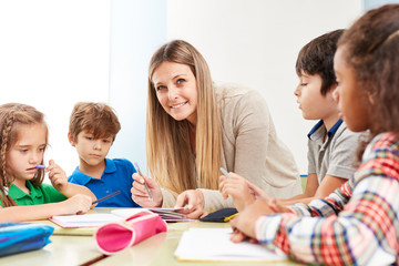 Schüler machen Hausaufgaben mit Lehrerin