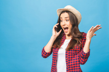 Amazed woman keeping mouth wide open, looking surprised, talking on mobile phone, conducting...