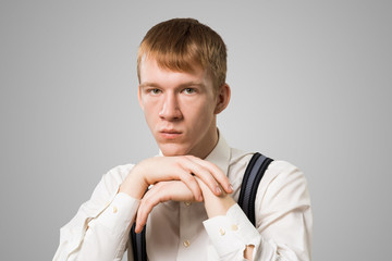 Sad young guy with arms touching his chin