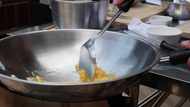 Cooking eggs in a wok. Step by step cooking pad thai. Thai cuisine. Closeup. 4k