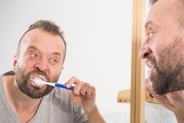 Fototapeta premium Man brushing his teeth in bathroom