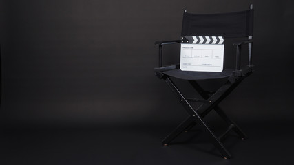 Clapperboard or clap board or movie slate with black director chair use in video production ,film, cinema industry on black background.
