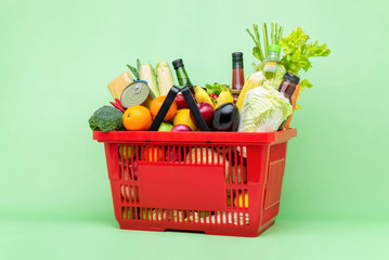 Colorful food and groceries in red supermarket plastic basket