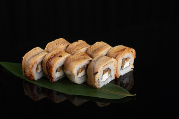 Tempura sushi with eel fish and cream cheese on black background