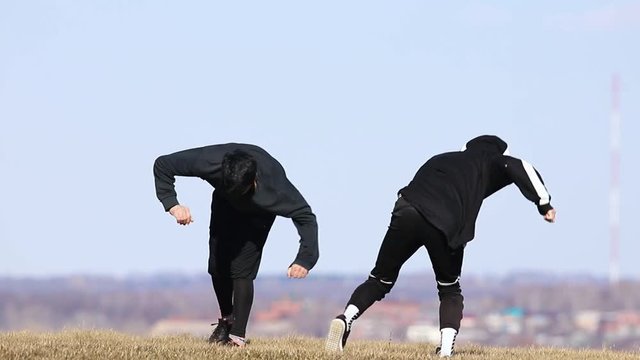 Three young men doing acrobatic tricks in the air. Performing somersault