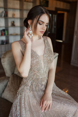Obraz na płótnie Canvas Beautiful woman in elegant evening dress. Beautiful young woman, model, in an evening dress indoors.A portrait of a beautiful elegant woman in the evening dress. Fashion, evening dresses for events.