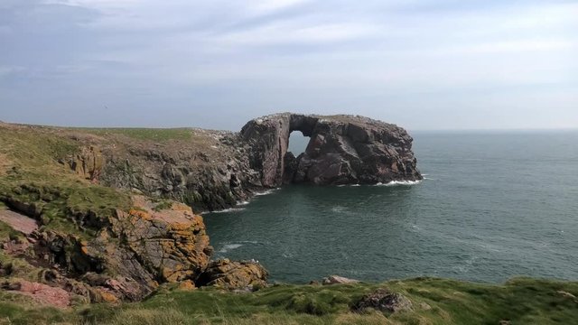 Long shot of Bullers cliffs looking to Dunbuy arch