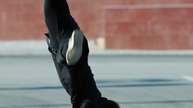 Young acrobatic man runs forward and performing flips