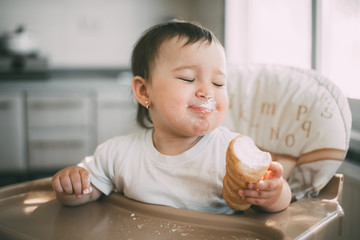 baby in the kitchen eagerly eating the delicious cream horns, filled with a vanilla cream