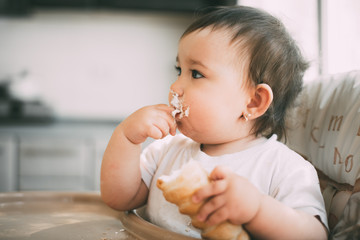 baby in the kitchen eagerly eating the delicious cream horns, filled with a vanilla cream