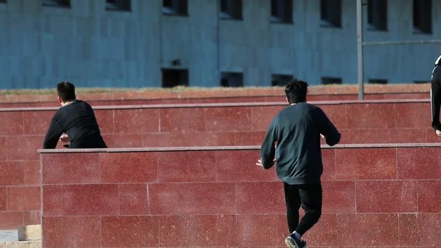 Three athletic young men overcoming obstacles