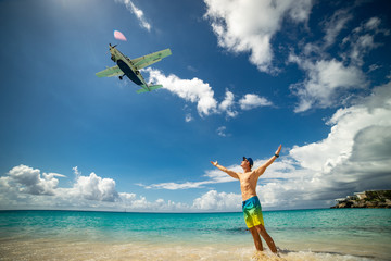 Man with airplane flying over on famous Maho beach