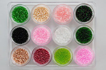 Obraz na płótnie Canvas Set of multicolored beads for embroidery and needlework in plastic jars