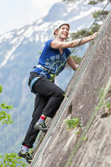 Female rock climber scaling a rock face at Oberried climbing garden, Otztal, Tyrol, Austria