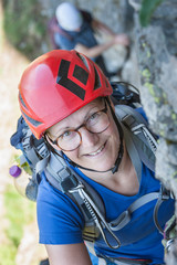 Woman climbing on rock face via ferrata towards Stuibenfall Waterfall, Otztal, Tyrol, Austria