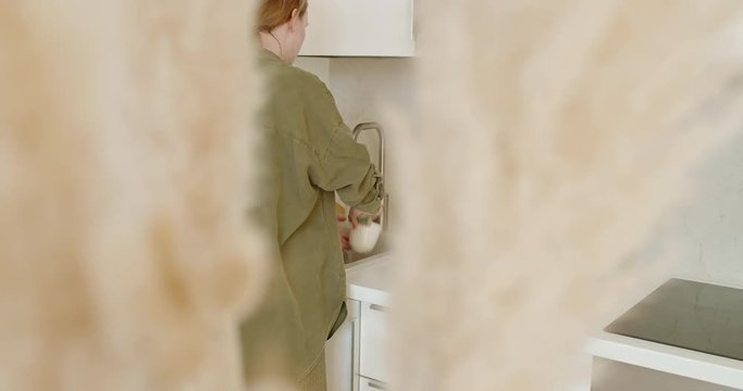 Young woman washing dishes in the kitchen.