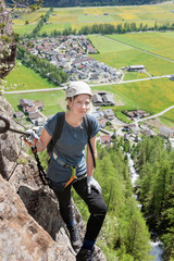 Woman climbing on rock via ferrata towards Lehner Waterfall, Otztal, Tyrol, Austria