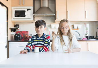Obraz premium Happy children eating a yogurt.