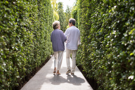 Happy Senior Couple Walking Arm In Arm