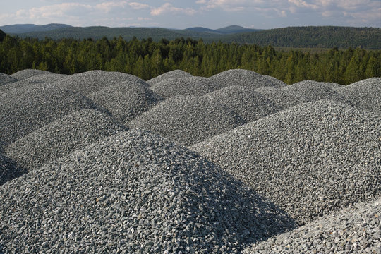 Gravel folded into large piles stored in the open air. High resolution and detail.