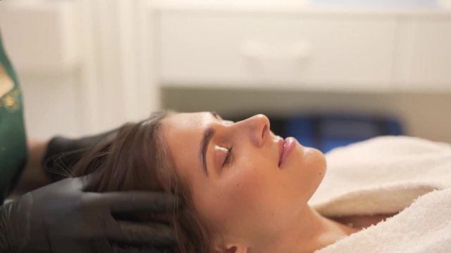 Profile of Caucasian Female Layind Down While Her Hair Specialist Massage Her Head in Mesotherapy Treatment, Light Camera Movement