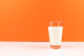 orange background with glass milk